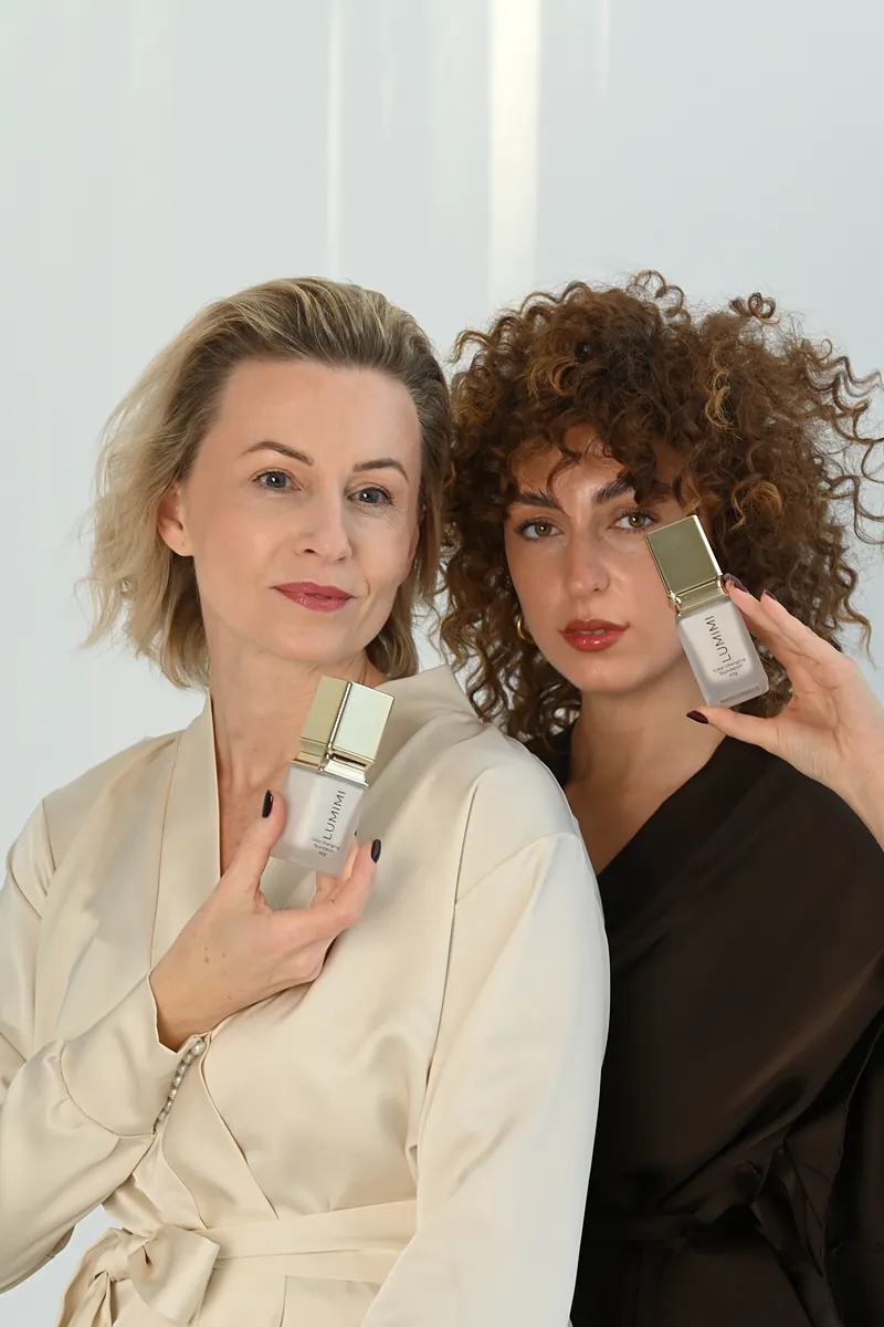 Two women of different ages holding LUMIMI foundation