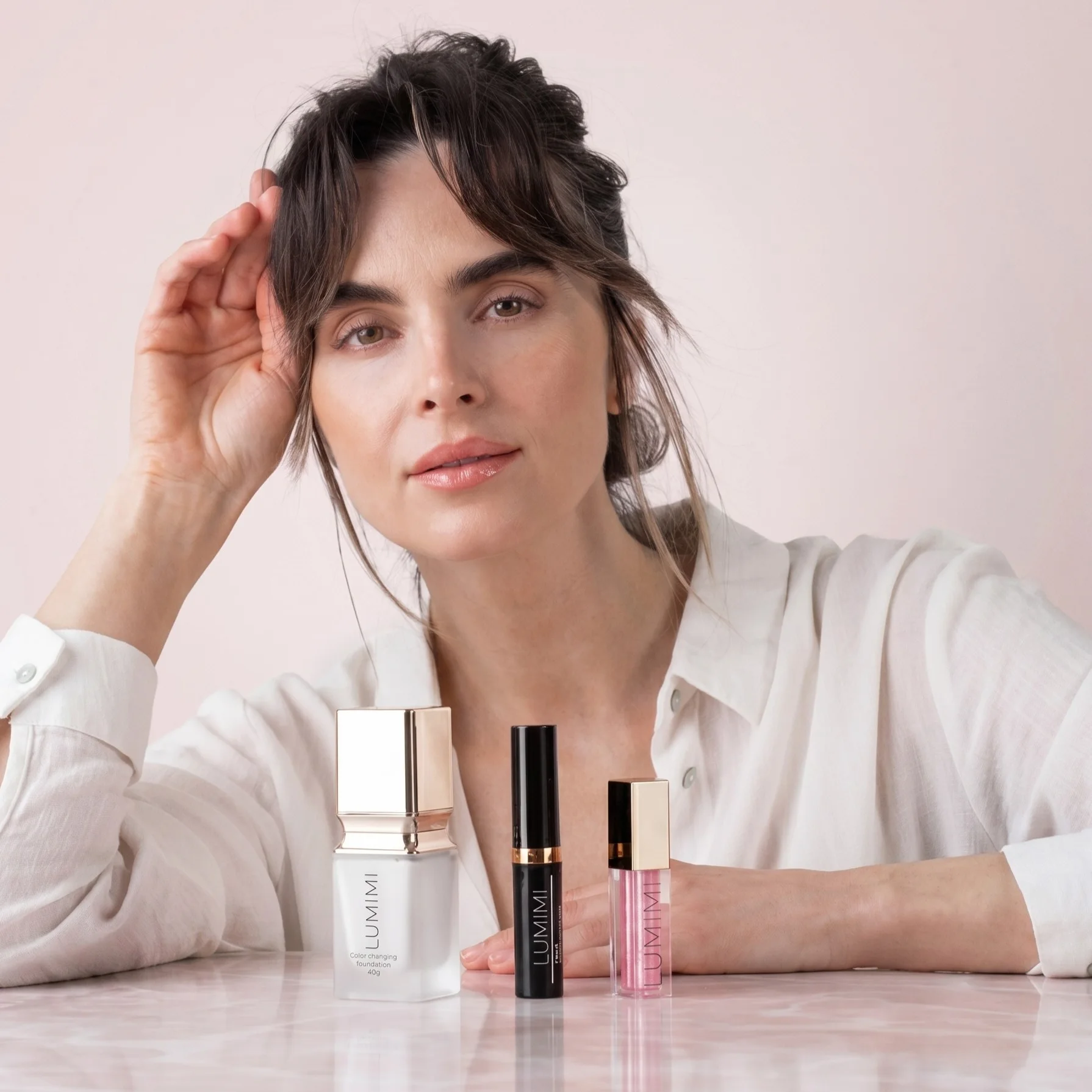 Tři bestsellery LUMIMI — make-up, řasenka a lesk na rty — společně na stole